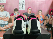 Rear view of the pair showing black heel panels, white side sections, pink collar accents, and Jumpman graphics.