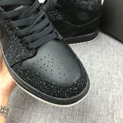 Close-up of the perforated toe box, black laces and speckled surrounding overlay.