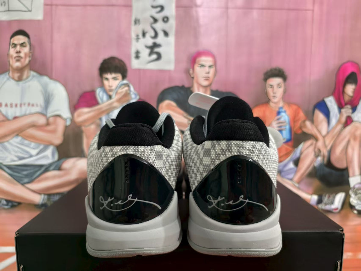 Rear view of black and grey Nike sneakers with patterned collars, black heel panels and light-coloured soles.