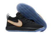 Black low-top Nike Book 1 shoe with tan Swoosh and blue outsole