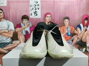 Front view of cream basketball shoes with black tongues and collars.