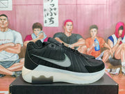 Side view of a black Nike sneaker with a gray swoosh, paneled upper, lace closure, and translucent-looking outsole.