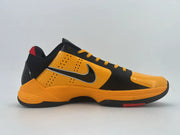 Side profile highlighting the orange side panel, Swoosh, and red outsole detail.