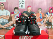 Front view of the black, red, and white Nike sneaker pair displayed on a red shoebox.
