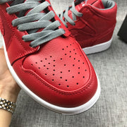 Close-up of the red perforated toe box and gray laces.