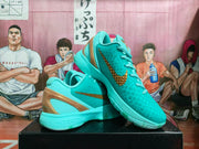 Angled view showing the turquoise textured upper, matching laces, gold-toned side branding, and sculpted heel detail.