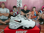 Side profile of a white Nike basketball sneaker with layered panels, black Swoosh, red outsole details and Air lettering.