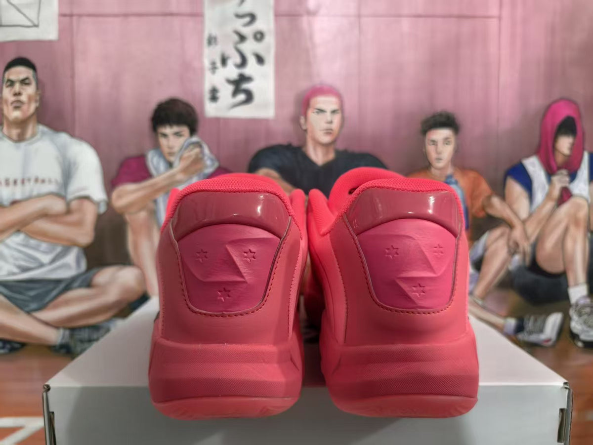 Rear view of a pair of pink Jordan basketball sneakers showing padded heel sections and Jumpman-style detailing against an illustrated backdrop.