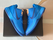 Pair of blue Kobe 6 shoes displayed on a dark box from above.