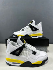 Close angled view of a white, yellow, and black Jordan Air Jordan 4 sneaker showing the mesh side panel and lace hardware.