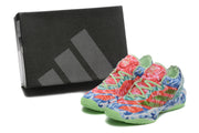 Pair of multicolor camouflage Adidas basketball sneakers beside a black Adidas shoe box