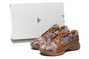 Brown and camouflage sneakers photographed with a white shoe box in the background.
