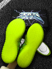 Neon green textured shoe soles shown over a black graphic shoe box.