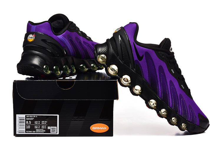 Purple and black Nike Air Max DN8 sneakers displayed with a shoe box; the box label shows a sample size.