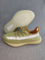 Side view of a green knit sneaker with a reflective stripe and translucent ribbed outsole, with the second shoe lifted to show the sole.