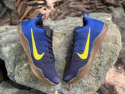 Top view of a pair of blue and navy Kobe 11 sneakers with yellow Swooshes and translucent brown outsoles
