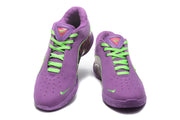 Front view of purple basketball sneakers with bright green laces, perforated toe boxes, and Nike swooshes.