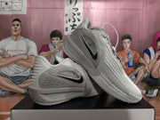 Angled view of a pair of grey Nike sneakers displaying the side branding, ridged upper, and outsole pattern.