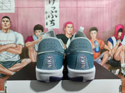 Rear view of Nike basketball sneakers in carbon gray and purple with white midsoles and heel branding.