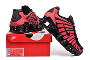 Black and pink Nike Shox TL-style sneakers shown with a box; box label visible.
