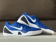 Pair of royal blue sneakers displayed together, showing the white midsoles, black heel panels, and side swooshes.