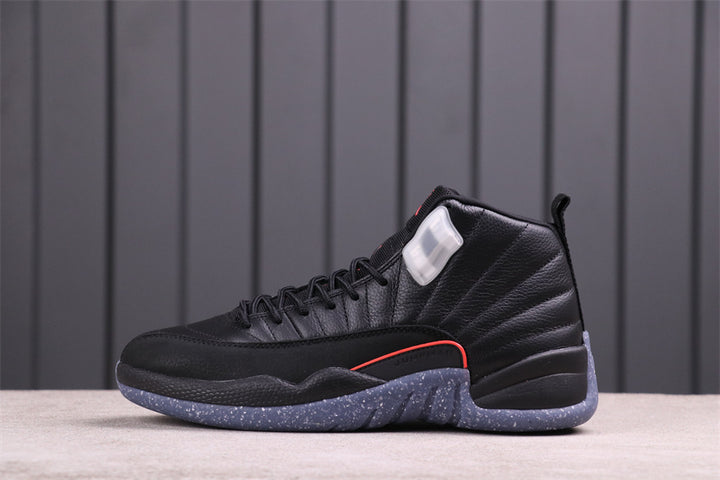 Side view of a black Air Jordan 12 high-top with red trim and a blue-gray speckled outsole.