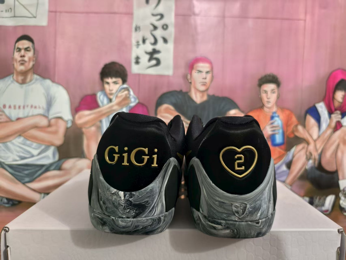 Rear view of black and gray GiGi sneakers with gold GiGi lettering and a heart-shaped number 2 detail.