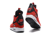 Rear views of red and black Nike Air Max 90 high-top sneakers, showing heel details and outsole.
