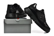 Pair of black Prada-branded sneakers shown from the side with a shoebox