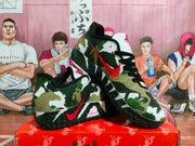 Angled view of a pair of military green camouflage basketball sneakers showing the red Swoosh, black laces, white panels, and outsole texture.