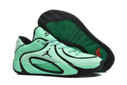 Jordan sneaker outsole view showing a black herringbone tread pattern with green detailing and a red accent.