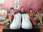Front view of white lace-up basketball shoes with perforated toes and purple tongue logos.
