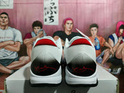 Rear view of black, white, and red basketball sneakers showing the textured white heel, black heel panels, and red collar accents.