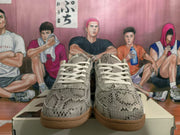 Front view of gray snakeskin-style patterned sneakers with light laces and gum-colored outsoles.