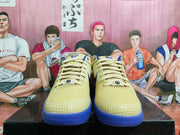 Front view of pale yellow Nike basketball shoes with blue soles and trim.