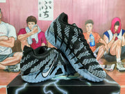 Angled view of a pair of black and gray Nike basketball shoes with patterned uppers and sculpted outsoles