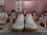 Front view of white Nike Kobe basketball shoes with coral-red details and gum-colored outsoles