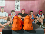 Underside view of the orange sneakers showing the molded tread pattern and heel details.