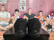 Rear view of the black sneakers showing heel branding, padded collars and textured heel construction.