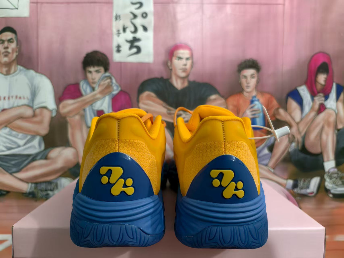 Rear view of yellow and blue sneakers showing the textured heel, decorative blue heel panels, and blue outsoles.