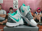 Pair of white and mint-green Nike Kyrie basketball shoes showing the patterned overlays and sculpted soles.