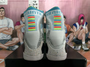 Rear view of the mismatched high-top sneakers showing gray uppers, multicolor heel accents, patterned panels, and white soles.