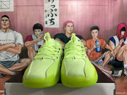 Front view of vivid green low-top basketball shoes with perforated uppers and laces.