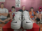 Front view of white and black Nike sneakers showing the lace-up design, toe logos and padded uppers.