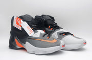 Pair of black, white, and orange Nike high-top basketball shoes shown from a front three-quarter angle.
