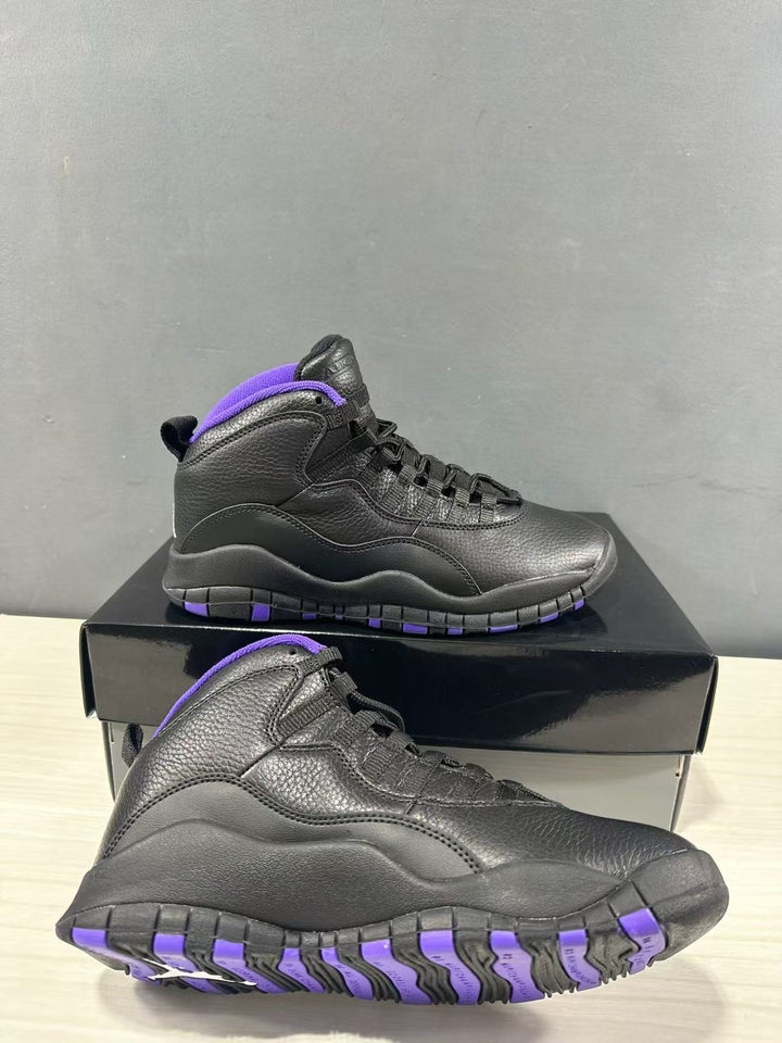 Pair of black high-top Jordan sneakers with purple collar and outsole accents, shown on a black shoebox.