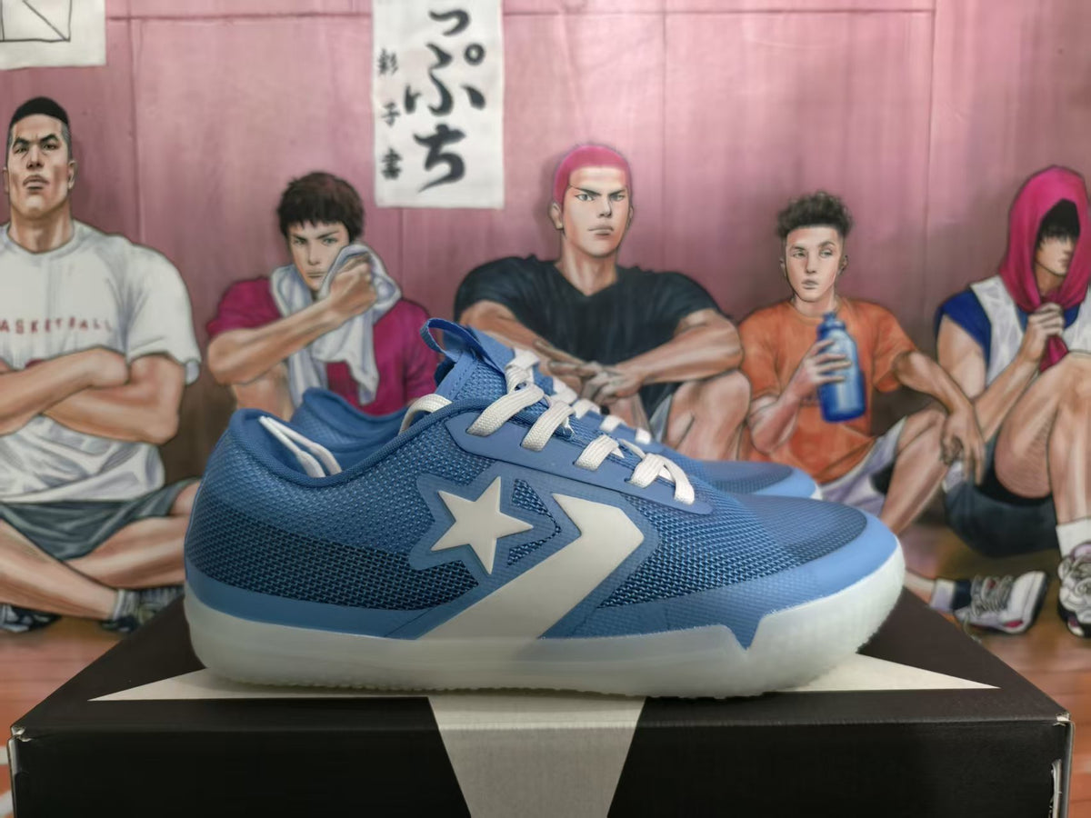 Side view of a blue low-top sneaker with a star-and-chevron side graphic, white laces, and a translucent off-white sole on a shoebox.