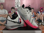 Angled view of grey Nike LeBron low-top basketball shoes with bright pink outsoles.