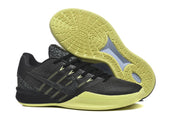 Side view of a black Kobe basketball shoe beside its patterned volt outsole.