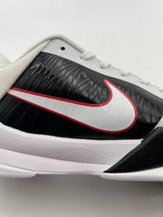 Side close-up of the white Swoosh with red edging against a glossy black panel